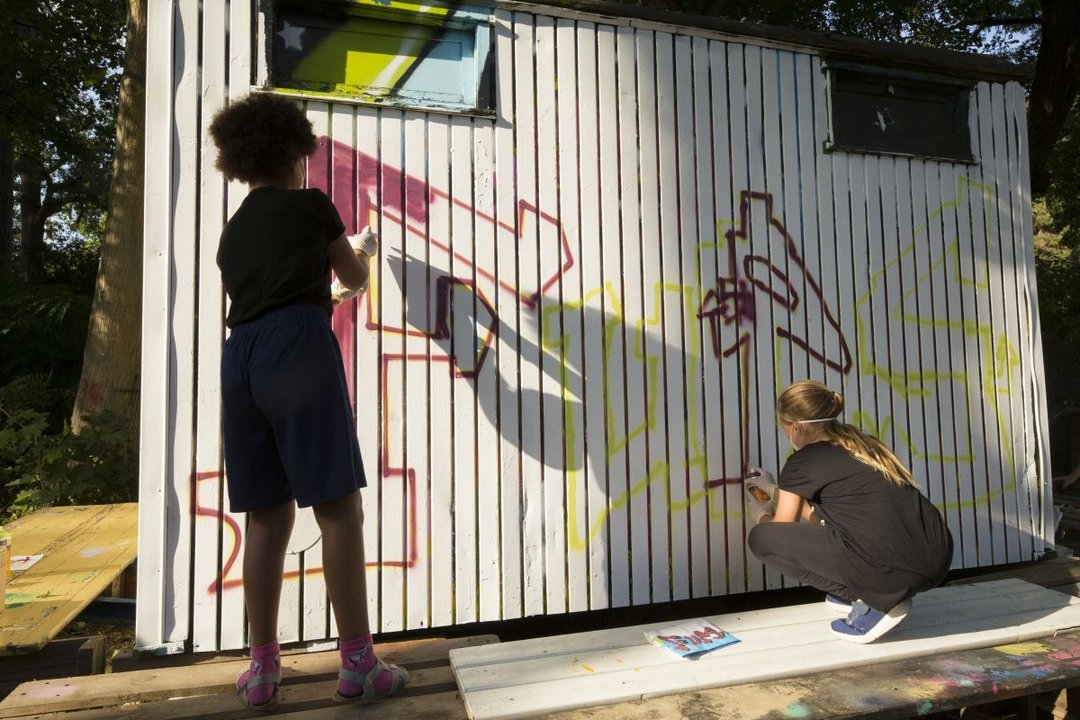 Zwei junge Menschen, Graffiti sprühend