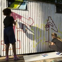 Zwei junge Menschen, Graffiti sprühend
