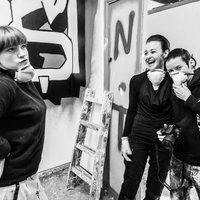 Drei junge Frauen posieren vor einem Graffiti