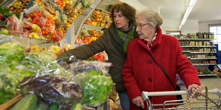 Junge und alte Frau beim Einkaufen am Obst- und Gemüsestand